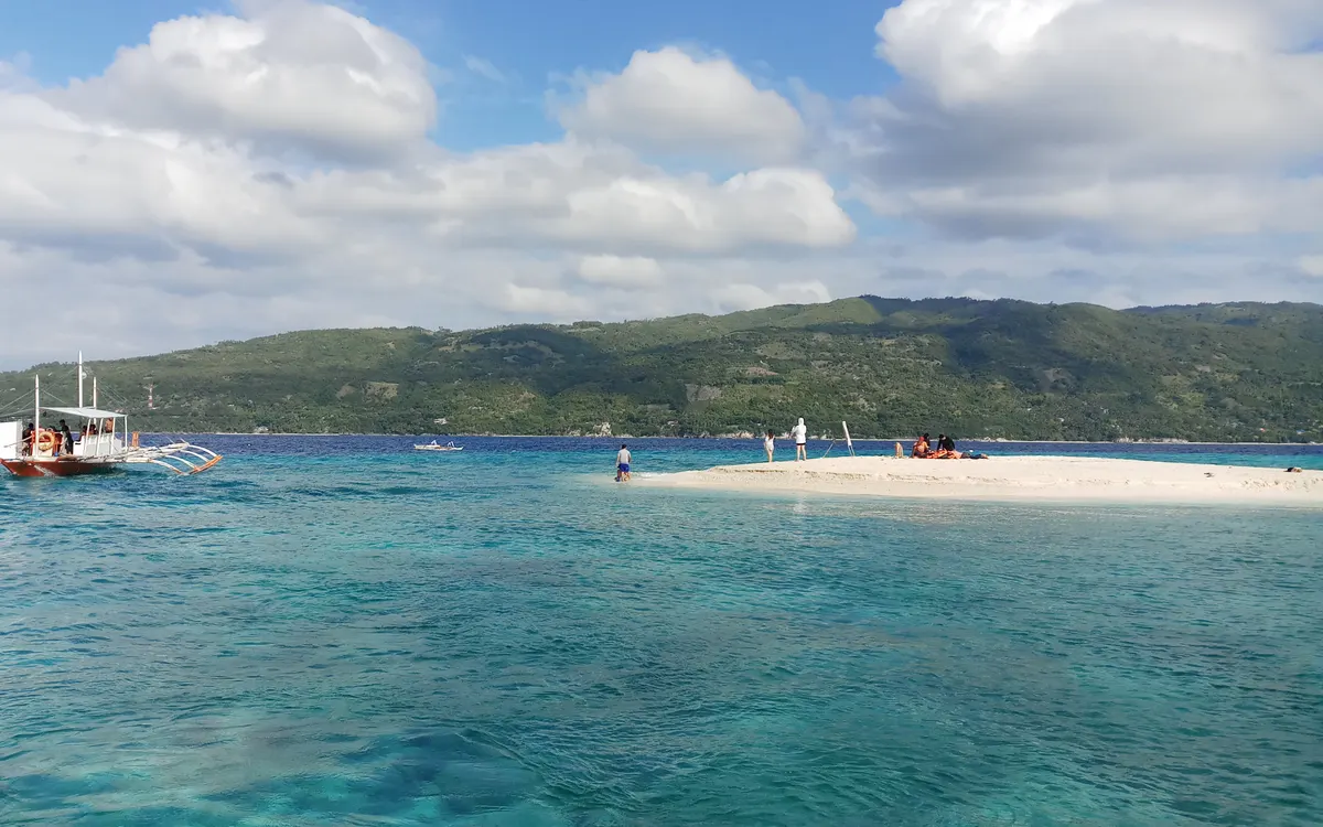 The shifting white sandbar of Sumilon Island off Oslob, Cebu, ringed by clear turquoise water
